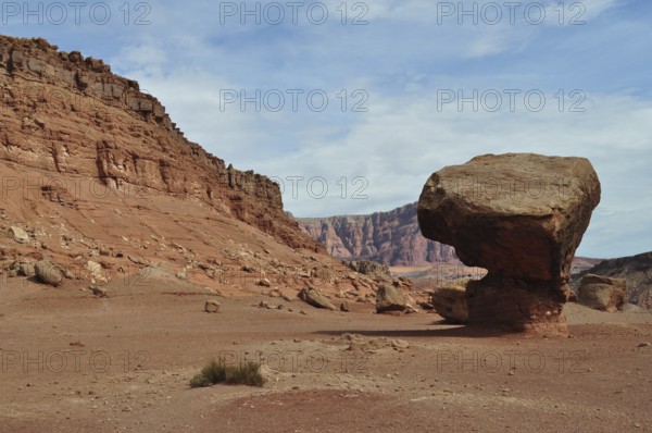 Huge single rock in a red desert landscape with cloudy sky, Grand Canyon National Park, Arizona, USA