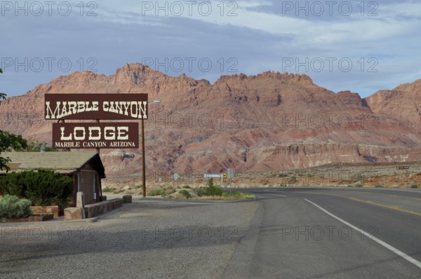 Lodge on a road in the desert in front of a rocky landscape with clouds in the sky, Grand Canyon National Park, Arizona, USA