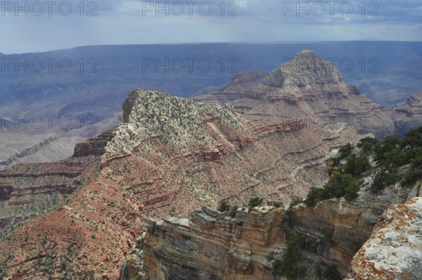 Extensive canyon landscape with rugged rock structure and bright light on an extensive rock chain, Grand Canyon National Park, Arizona, USA