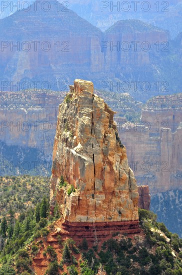 A massive rock rises steeply in a canyon landscape, surrounded by other rocks and sparse vegetation, Grand Canyon National Park, Arizona, USA
