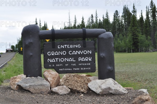 Grand Canyon National Park entrance sign surrounded by trees and stones, Grand Canyon National Park, Arizona, USA