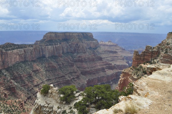 Extensive view of a canyon with deep valleys and steeply sloping cliffs under a cloudy sky, Grand Canyon National Park, Arizona, USA
