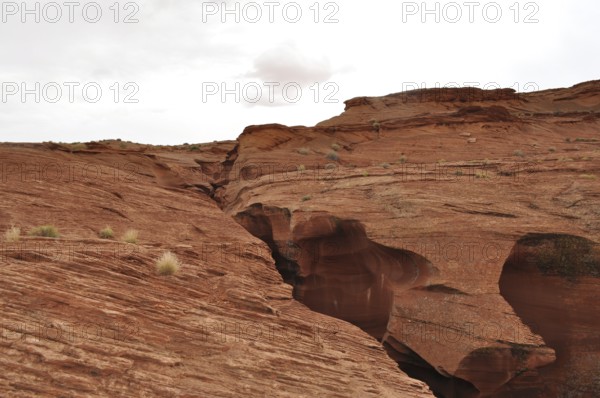 Wide rocky landscape with heavily eroded sandstone formations and a cloudy sky, Antelope Canyon, Navajo Nation Reservation, Lake Powell Tribal Park, Arizona, USA