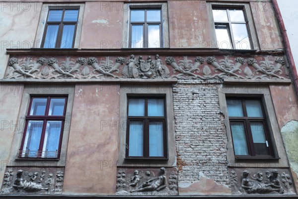 Relief band with cornucopias and figures on a dilapidated house façade from the 19th century, Lemberg, Ukraine