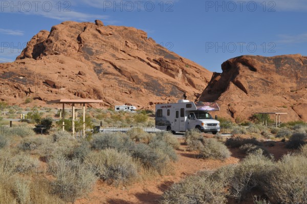 RV on campground in desert landscape with large red rocks and sparse vegetation, Valley of Fire State Park, Nevada, USA