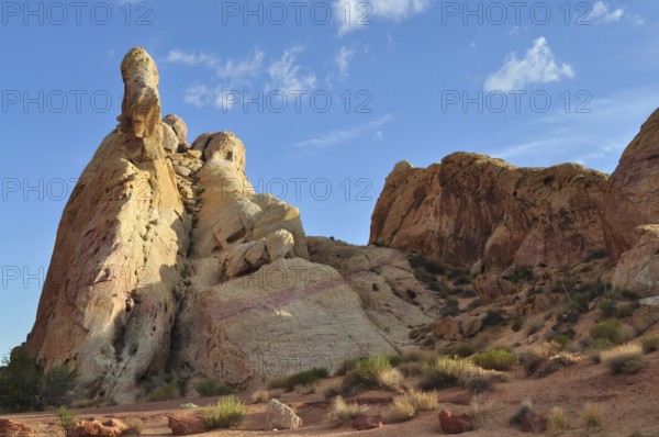Dramatic sandstone cliffs rise into the sky under bright sunshine and blue skies, Valley of Fire State Park, Nevada, USA
