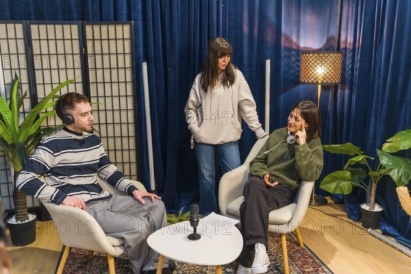 Three young people collaborating in a modern studio setup, creating audio content for a podcast or social media, utilizing microphones and headphones for engaging discussions