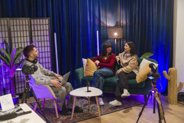 Young multiethnic creators collaborating on a podcast and social media video in a modern studio with cameras, microphones, lighting and casual, professional production setup