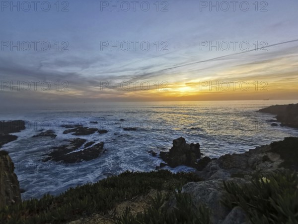 A peaceful sunset over the moving sea with intense colors in the sky, hiking on the Fisherman's Trail, hiking on the Fisherman's Trail, Southwest Alentejo nature park Park and Vicentina Coast, Portugal, Portugal