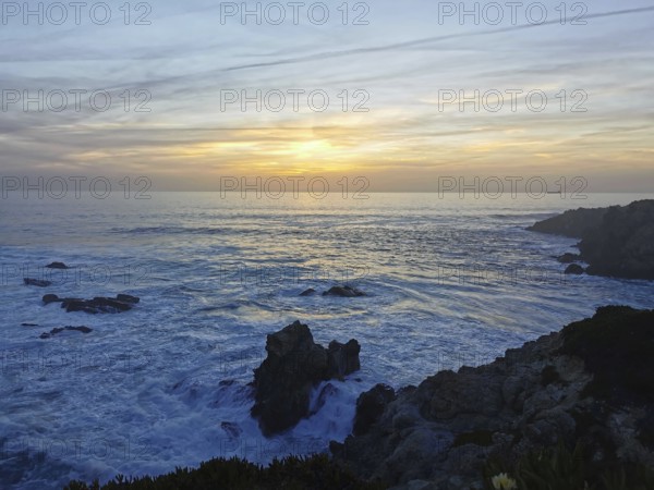 The sunset draws bright colors across the sea as waves hit the rocks, hiking the Fisherman's Trail, hiking the Fisherman's Trail, Southwest Alentejo nature park Park and Vicentina Coast, Portugal, Portugal
