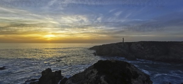 A coastal scene with a lighthouse at sunset. The clouds color the sky colorful, hiking on the Fisherman's Trail, hiking on the Fisherman's Trail, Southwest Alentejo nature park Park and Costa Vicentina, Portugal, Portugal