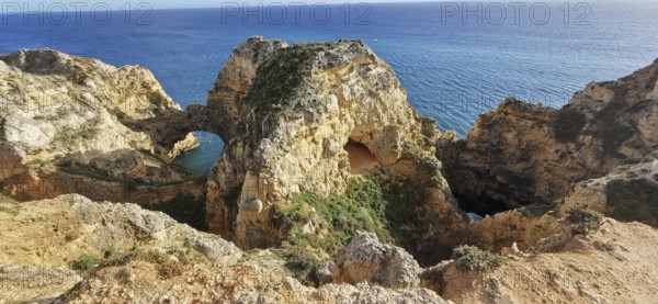 Archway, dramatic rock formations overlooking the calm blue sea, Lagos, Algarve, Portugal