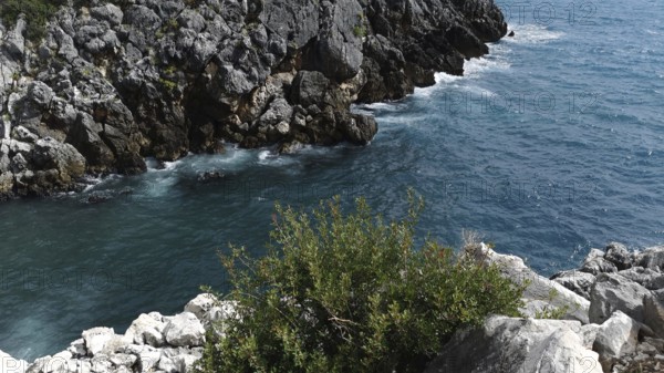 Rocky coast with deep blue water and strong waves, Dhermi, Albanian Riviera, Albania