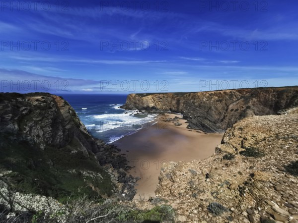 Extensive coastal view with dramatic cliffs and deep blue ocean under a clear sky, hiking on the Fisherman's Trail, Algarve, Portugal