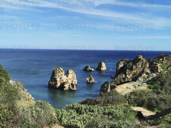 Rocky coastline with distinctive outcrops over the deep blue sea, Lagos, Algarve, Portugal