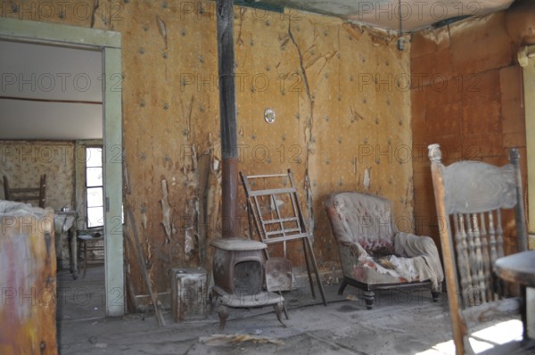 An abandoned room with old furniture and peeling wallpaper that exudes a dilapidated and antique atmosphere, Bodie Ghost Town, California, USA