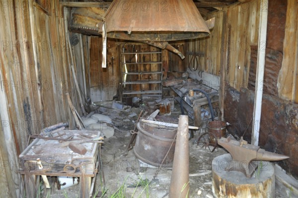An old blacksmith workshop with rusty tools and wooden structures in an abandoned state, Bodie Ghost Town, California, USA