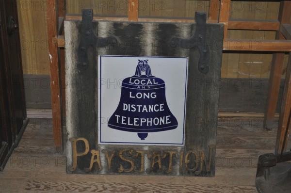 A historic telephone sign on a wooden board in an abandoned room, Bodie Ghost Town, California, USA