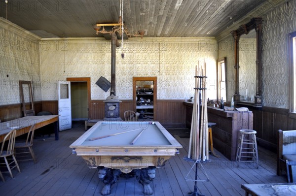 An abandoned billiard room in a saloon with antique rustic decor and wooden furniture, Bodie Ghost Town, California, USA