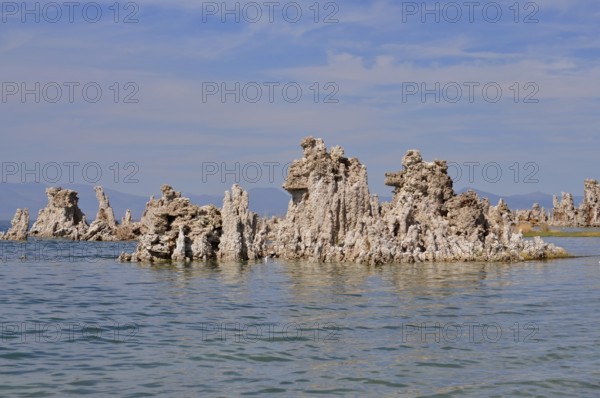 Unique rock structures, limestone formations rising from the calm water of a lake under a clear sky, Lake Natron, Mono Lake, California, USA