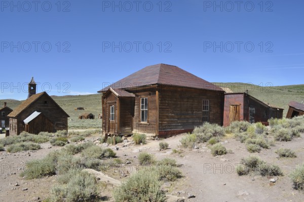 Abandoned wooden houses in the middle of a sandy and dry landscape, Bodie Ghost Town, California, USA