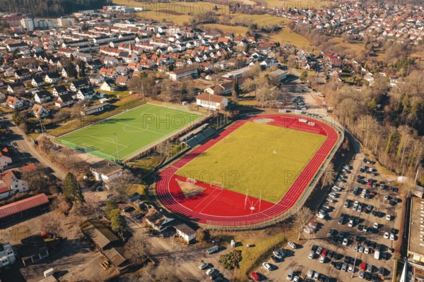 Stadium with soccer field and red track adjacent to a residential area, Wimberg, Calw, Germany