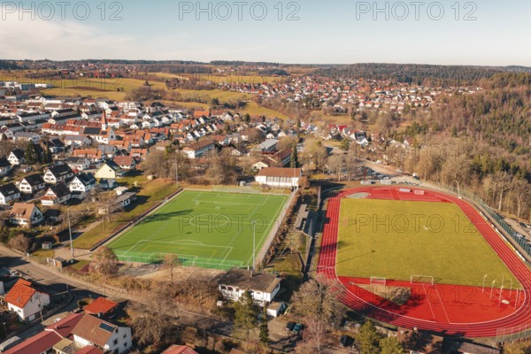 Aerial view of two neighboring sports fields in a village with soccer field and running track, Wimberg, Calw, Germany
