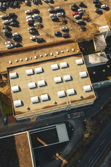 Aerial view of a parking lot and roof of a sports hall in sunshine in a winter environment, Wimberg, Calw, Germany