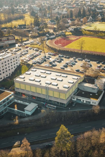 School complex with sports field and large parking lot, surrounded by winter countryside, Wimberg, Calw, Germany