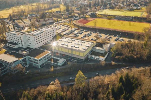 Picture of a school complex with a sports hall, parking lot and a sports field in a wintry landscape, Wimberg, Calw, Germany