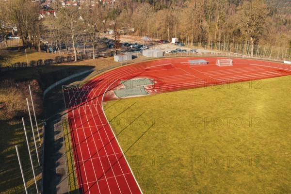Sports field with red track and shade, surrounded by trees and green space, Wimberg, Calw, Germany