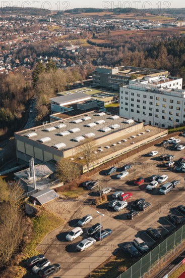 Industrial area with large buildings and lots of parked cars, wintry atmosphere, view of the city, Wimberg, Calw, Germany