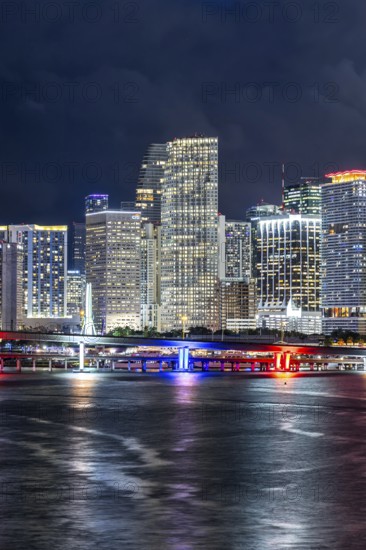 Miami skyline with high-rise real estate in downtown by the ocean at night in Miami, USA