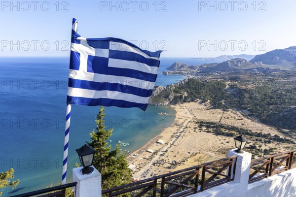 View of Tsambika beach from above with Greek flag Mediterranean seaside island of Rhodes, Greece