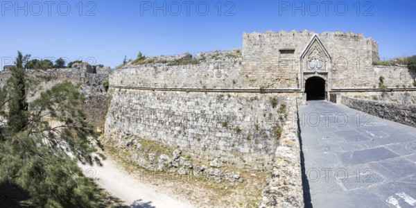Red gate from the Middle Ages in the city wall of the historic old town Panorama on the island of Rhodes, Greece