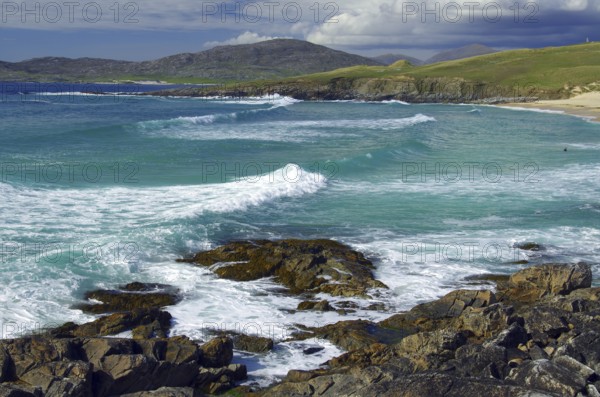 Dramatic coastal scene with breaking waves over rocky shore under cloudy sky, Isle of Harris, Outer Hebrides, Scotland, United Kingdom