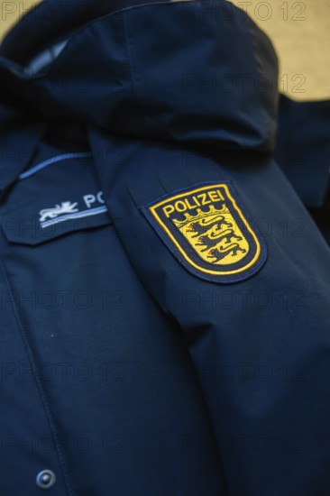 Close-up of a police jacket with a prominent badge on the sleeve
