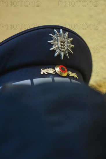 Police cap with badge in blue fabric viewed from close