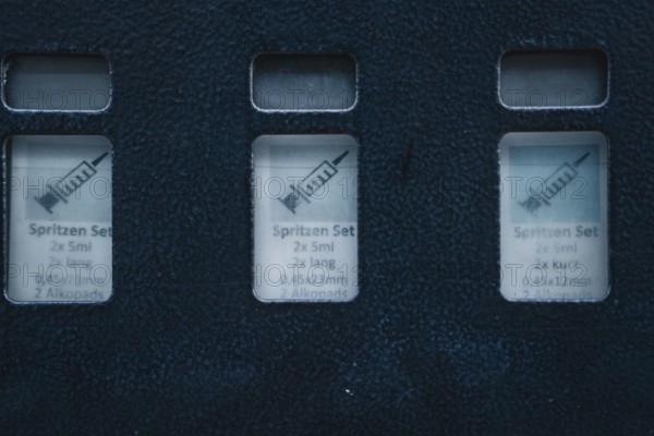 Close-up view of medical syringe sets in blue packaging