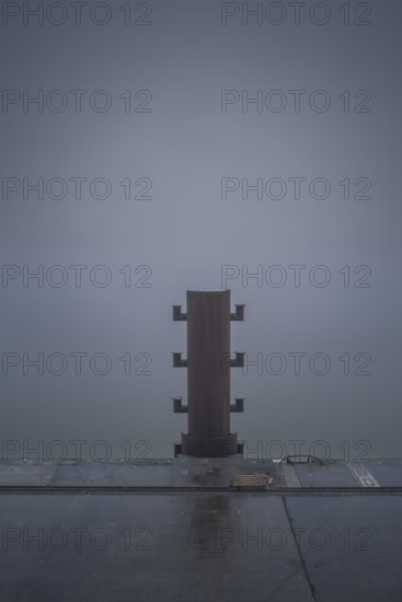 View of a bollard on the quay in fog, Cuxhaven, Lower Saxony, Germany