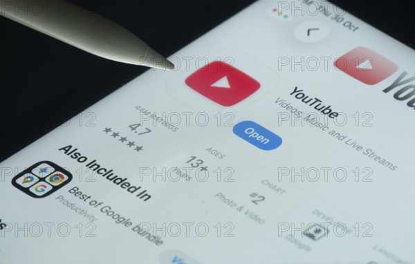 Dhaka, Bangladesh- 30 Oct 2025: Youtube app on a iPad screen with a pen pointing at the install option