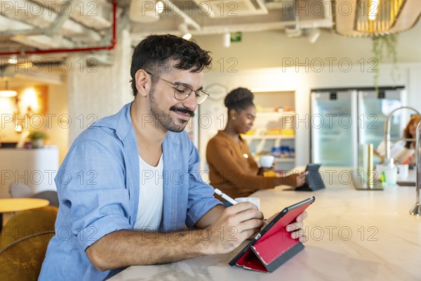 Diverse individuals making notes on a digital tablet and drinking coffee in a modern coworking space. Illustrating teamwork. Communication. And technological integration in a professional environment