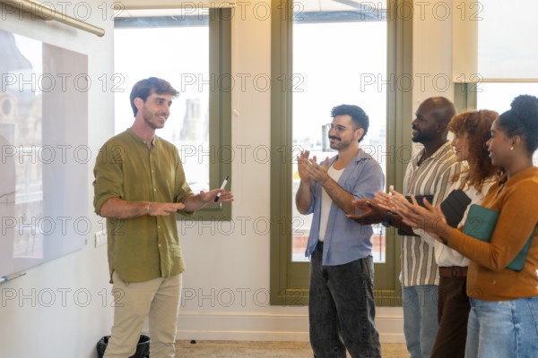 Diverse business colleagues showing appreciation for a successful presentation in a bright coworking space, fostering teamwork, collaboration, and collective success