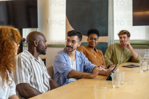 Diverse group of colleagues meeting in a modern office, collaborating and discussing ideas during a brainstorming session or break, fostering teamwork and professional interaction