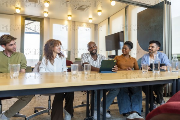 Diverse business colleagues collaborating in a modern office, sharing ideas and working together during a meeting, showing teamwork, communication, and smiling faces
