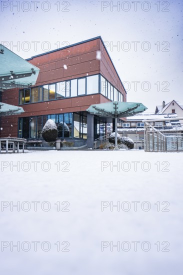 Modern town hall building with glass fronts in a snowy winter landscape, Gechingen, Calw district, Germany