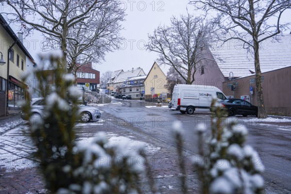 Snowy village road with parked cars and traditional ensemble of houses, Gechingen, Calw district, Germany