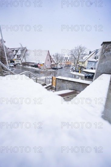 Snowy street in an urban area with numerous houses, Gechingen, Calw district, Germany