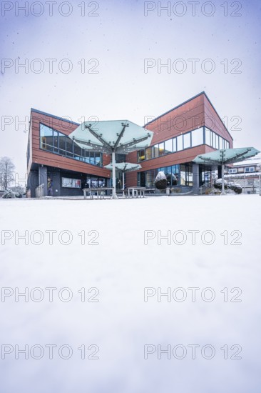 Modern town hall, predominantly glazed building in snowy, wintry surroundings, Gechingen, Calw district, Germany