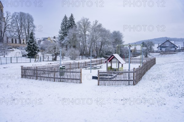 A snowy playground in a small village surrounded by trees, Gechingen, Calw district, Germany
